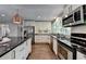 Updated kitchen featuring stainless appliances, white cabinetry, and hardwood flooring for a sleek design at 945 Tiber Cir, Alpharetta, GA 30022