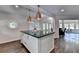 Bright kitchen with a large island, modern lighting, and seamless transition to dining and living areas at 945 Tiber Cir, Alpharetta, GA 30022