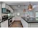Bright kitchen features stainless appliances, island with breakfast bar, and copper pendant lighting at 945 Tiber Cir, Alpharetta, GA 30022