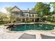 A luxurious backyard featuring a pool, patio, mature trees, and outdoor seating at 1556 Gaylor Se Dr, Smyrna, GA 30082