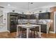 Modern kitchen featuring dark cabinets, stainless steel appliances, a center island, and designer backsplash at 1556 Gaylor Se Dr, Smyrna, GA 30082