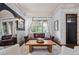 Bright living room featuring a leather sofa, wooden coffee table, and large windows with natural light at 1556 Gaylor Se Dr, Smyrna, GA 30082