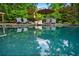 Sparkling pool reflecting the lush greenery, surrounded by comfortable lounge seating for ultimate relaxation at 1556 Gaylor Se Dr, Smyrna, GA 30082