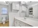 This bathroom features a sink with cabinets, a large mirror, toilet, and a window at 1605 Saddlecreek Rd, Auburn, GA 30011