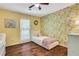 This sunny room features a floral wallpaper, ceiling fan, and wood floor at 1605 Saddlecreek Rd, Auburn, GA 30011