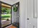 View of a black front door with a wreath, light, and view of the landscaped front yard at 1605 Saddlecreek Rd, Auburn, GA 30011