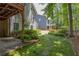 A backyard featuring a covered patio, mature landscaping, stepping stones and lush lawn at 1668 Macy Ln, Lawrenceville, GA 30043