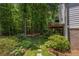 Charming backyard with stone paver walkway leading past mature trees and a wood deck at 1668 Macy Ln, Lawrenceville, GA 30043