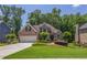 Beautiful brick home with a pristine lawn, mature trees, and an attached two-car garage at 1668 Macy Ln, Lawrenceville, GA 30043