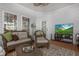 Relaxing screened porch featuring a cozy seating area and a modern television at 1668 Macy Ln, Lawrenceville, GA 30043