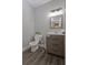 Modern half-bathroom features updated fixtures, gray walls, and dark wood-look floors at 1668 Macy Ln, Lawrenceville, GA 30043