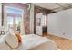 Comfortable bedroom with exposed brick, balcony access, and stylish decor at 3235 Roswell Ne Rd # 702, Atlanta, GA 30305
