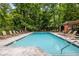 Relaxing community pool area with lounge chairs surrounded by lush greenery and shade at 3235 Roswell Ne Rd # 702, Atlanta, GA 30305