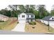 An aerial view of a white two-story home, showcasing its well-manicured lawn and proximity to nature at 3410 Summerpoint Xing, Cumming, GA 30028