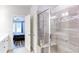 This is a modern shower with a glass door and stone tile design and view into the bedroom at 3410 Summerpoint Xing, Cumming, GA 30028