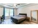 Spacious bedroom featuring hardwood floors, a tray ceiling, and large windows at 3410 Summerpoint Xing, Cumming, GA 30028