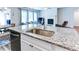 Kitchen island with a stainless steel sink, offering a functional workspace and views of the open living area at 3410 Summerpoint Xing, Cumming, GA 30028