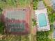 Aerial view of community tennis courts and pool with surrounding greenery; community parking is also visible at 705 Beaufort Cir, Duluth, GA 30096