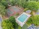 Aerial view showcasing the community pool and tennis courts surrounded by lush green trees at 705 Beaufort Cir, Duluth, GA 30096
