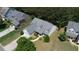 Aerial view of the home with a well-manicured lawn, mature trees, and a two-car garage at 1575 Parkside Village Dr, Cumming, GA 30040