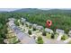 Aerial view of a neighborhood with mature trees and mountain views in the distance at 1575 Parkside Village Dr, Cumming, GA 30040