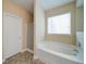 Bright bathroom featuring a soaking tub, a separate shower, a window, and tile flooring at 1575 Parkside Village Dr, Cumming, GA 30040