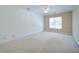 Spacious bedroom with neutral carpet, a ceiling fan, and a large window providing natural light at 1575 Parkside Village Dr, Cumming, GA 30040