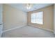 Inviting bedroom with beige walls, white trim, plush carpet, and a window providing natural light at 1575 Parkside Village Dr, Cumming, GA 30040
