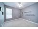 Cozy bedroom with gray walls, white trim, plush carpet, and a window for natural light at 1575 Parkside Village Dr, Cumming, GA 30040