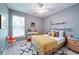 bedroom with modern color scheme, ceiling fan, window and geometric area rug at 1575 Parkside Village Dr, Cumming, GA 30040