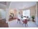 Light and airy dining room featuring a white table, pink chairs, modern chandelier and a bright window at 1575 Parkside Village Dr, Cumming, GA 30040
