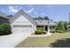 Charming one-story home with a well-manicured lawn, a two-car garage and complemented by lush green landscaping at 1575 Parkside Village Dr, Cumming, GA 30040
