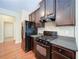 Well-equipped kitchen featuring dark cabinets, stainless steel appliances, and stylish backsplash at 1575 Parkside Village Dr, Cumming, GA 30040