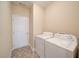 Functional laundry room equipped with a washer, dryer, and ample storage space at 1575 Parkside Village Dr, Cumming, GA 30040
