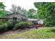 A home's backyard features a deck, green trees, and is surrounded by lush foliage at 2031 Dennis Pl, Buford, GA 30519