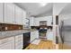 Well-lit kitchen featuring granite countertops, white cabinetry, stainless steel appliances, and modern lighting at 2031 Dennis Pl, Buford, GA 30519