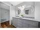 Stylish bathroom with a double sink vanity, gray cabinets and round mirrors above, next to another room at 717 Beaufort Cir, Duluth, GA 30096