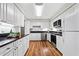 Bright kitchen showcasing white cabinetry, stainless steel appliances, and hardwood flooring at 717 Beaufort Cir, Duluth, GA 30096