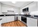 Modern kitchen features stainless steel appliances, dark countertops, white cabinets and hardwood style flooring at 717 Beaufort Cir, Duluth, GA 30096