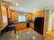 Kitchen featuring wood cabinets, granite countertops, and modern, black appliances at 8967 Midlothian Ct, Winston, GA 30187