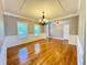 Bright living room with hardwood floors, decorative molding, large windows, and an elegant chandelier at 8967 Midlothian Ct, Winston, GA 30187