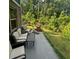 Back patio with outdoor seating, grill, and green backyard with an easy view of the surrounding woods at 201 Jonquil Spring Rd, Woodstock, GA 30188