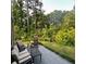 Back patio with an outdoor seating area, a grill, and a view of the green lawn and woods beyond at 201 Jonquil Spring Rd, Woodstock, GA 30188