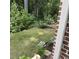 Grassy backyard with garden bed and brick facade at 201 Jonquil Spring Rd, Woodstock, GA 30188
