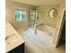 Luxurious bathroom featuring a soaking tub, walk-in shower, and large window at 201 Jonquil Spring Rd, Woodstock, GA 30188