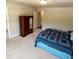 The bedroom features a bed with a blue quilt and an armoire with a mirror in a spacious room at 201 Jonquil Spring Rd, Woodstock, GA 30188