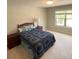This bedroom features a comfortable bed with a blue quilt, a bedside table, and a window at 201 Jonquil Spring Rd, Woodstock, GA 30188