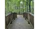 Picturesque wooden bridge amidst a lush green forest, perfect for nature walks at 201 Jonquil Spring Rd, Woodstock, GA 30188