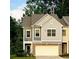 Two-story townhome featuring brick accents and a two-car garage at 201 Jonquil Spring Rd, Woodstock, GA 30188