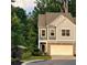 View of townhome exterior with a two-car garage and landscaping at 201 Jonquil Spring Rd, Woodstock, GA 30188
